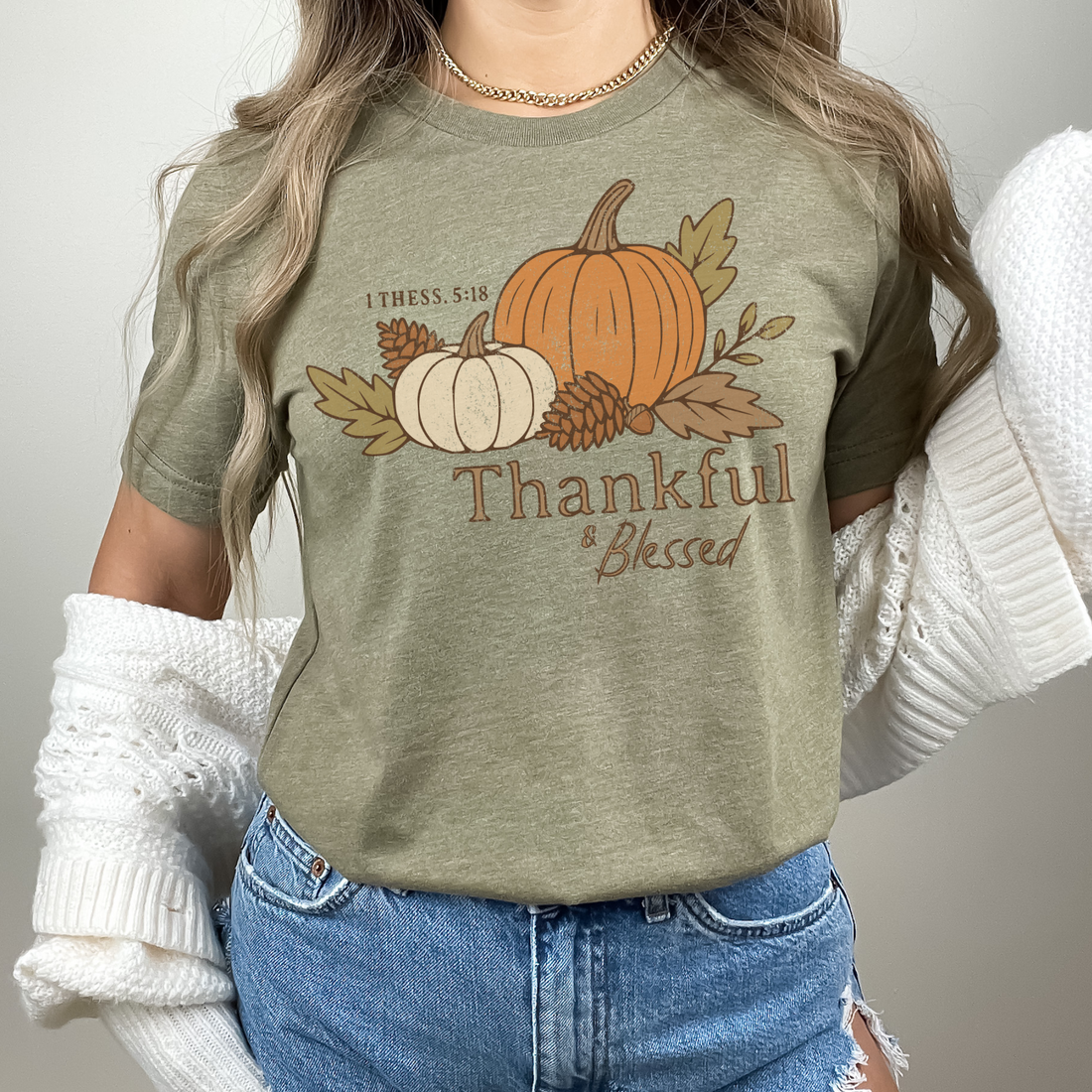 Person wearing a green t-shirt with a pumpkin and leaf design and text &